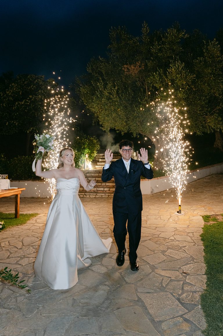 George & Nafsika, wedding in Aigio: the couple walking out between sparklers