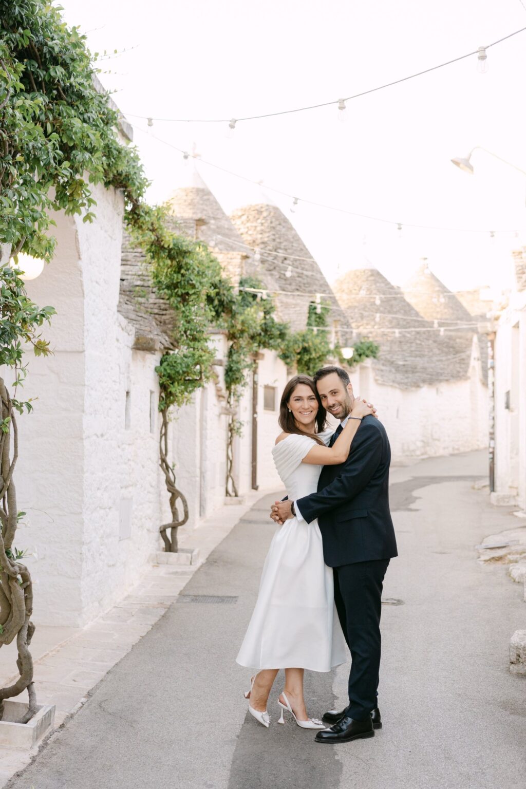 Couple embracing in an Alberobello lane with climbing vines
